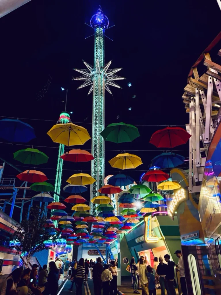 Gröna Lund amusement park illuminated at night with colourful umbrellas and rides
