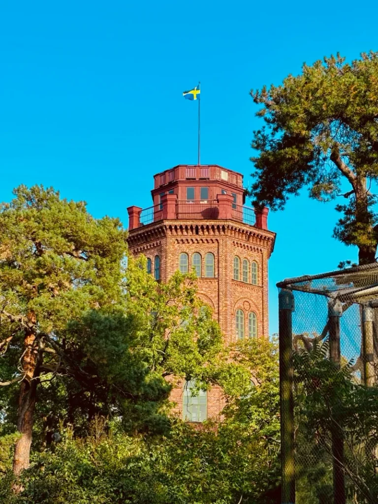Brick tower of Nordiska Museet in Stockholm with a Swedish flag above it