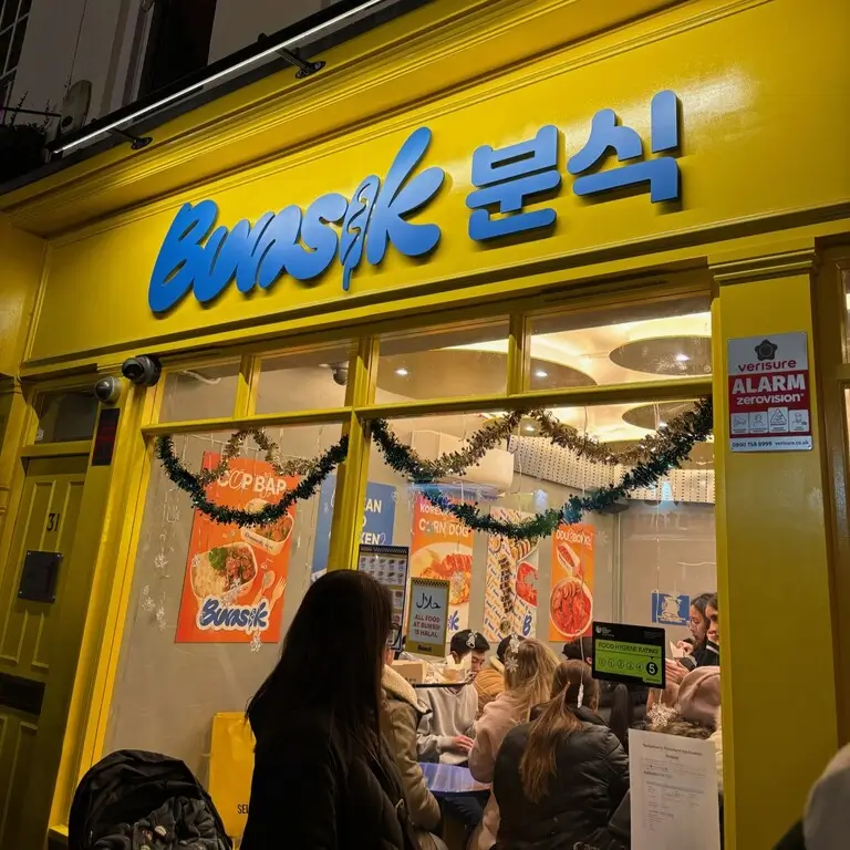 Authentic Bunsik shop in Chinatown, showcasing traditional Korean street food with colorful signage and bustling atmosphere