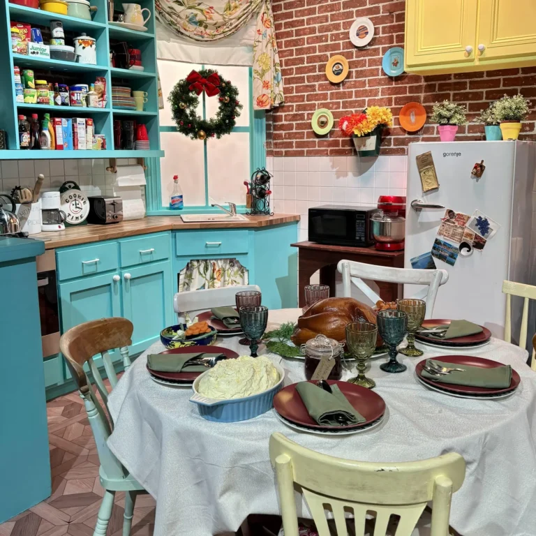Monica's Kitchen at the Friends Experience, showcasing the iconic orange walls, purple accents, and the famous kitchen setup from the beloved TV show 'Friends.