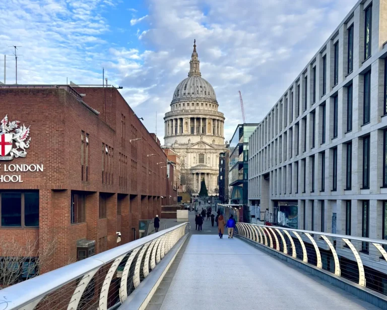 Beautiful view of St. Paul's Cathedral in London, with its iconic dome and intricate architectural details, standing tall against a clear blue sky.